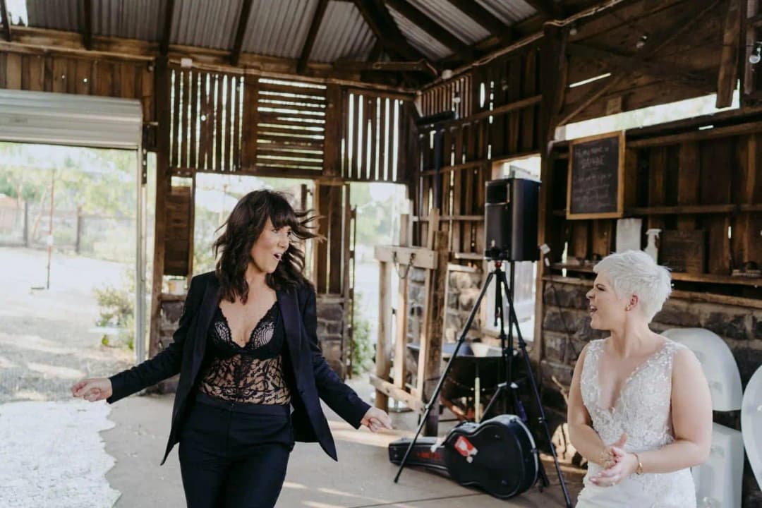 Couple smiling at each other as they enter the reception barn