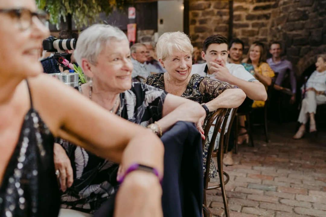 Guests leaning forward and smiling at the reception table