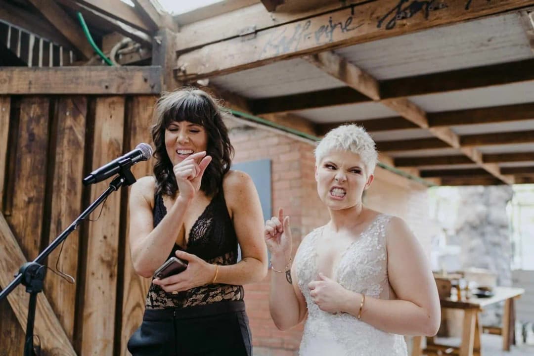 Couple laughing together while making a speech at a microphone