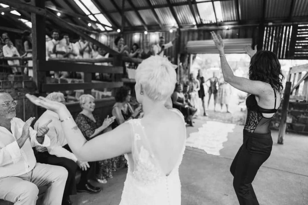 Black-and-white photograph of the couple dancing with arms raised