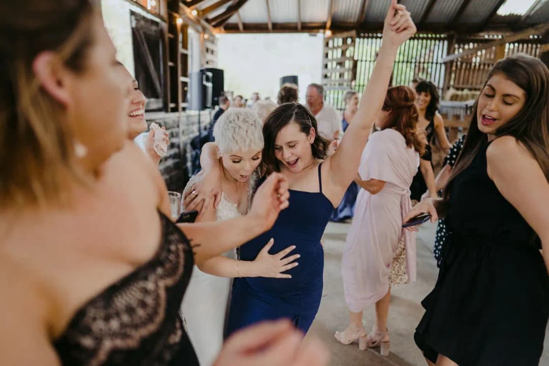 Couple dancing together beside a guest in a blue dress
