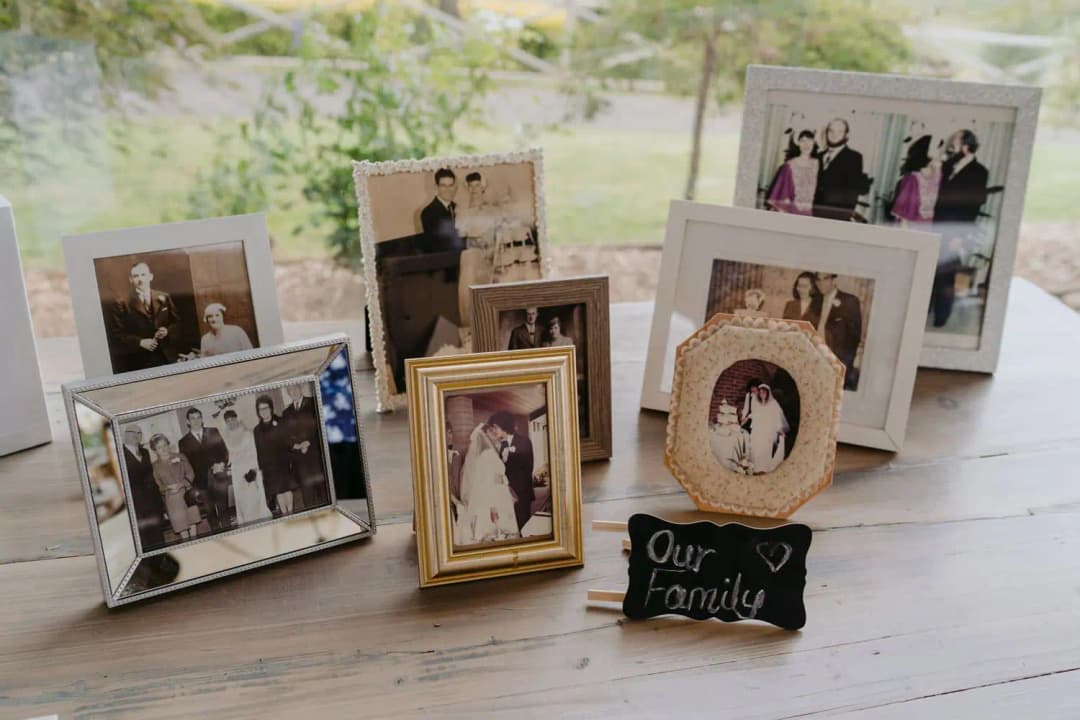 Framed family wedding photographs arranged on a table beside an Our Family sign