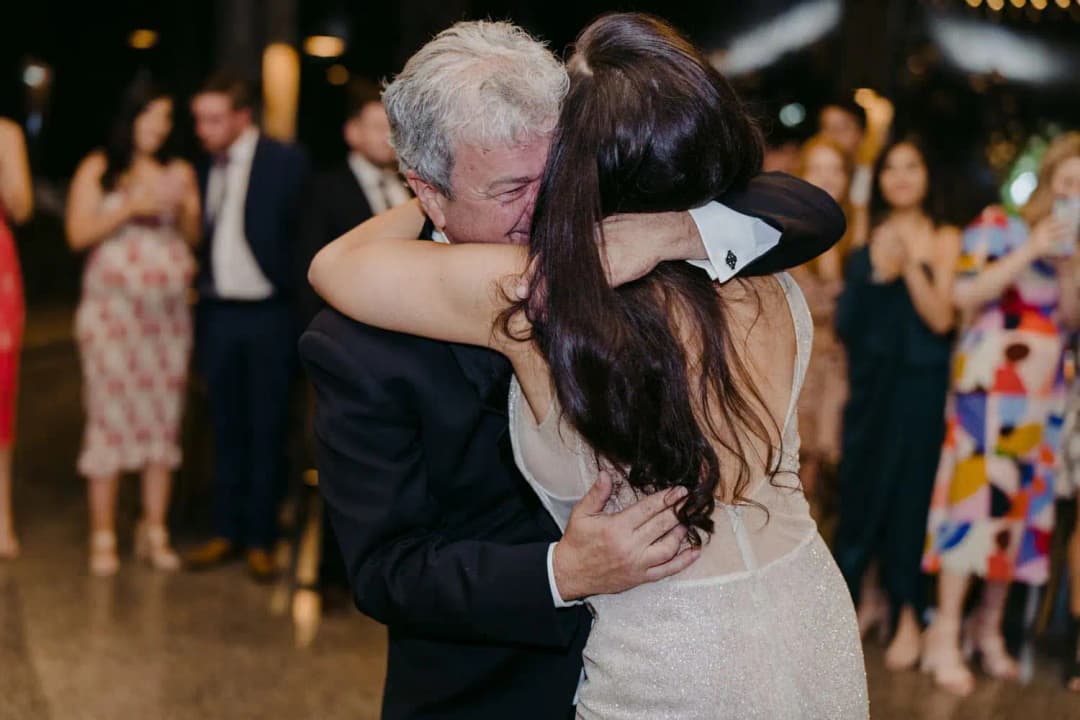 Bride embracing a grey-haired man on the dance floor