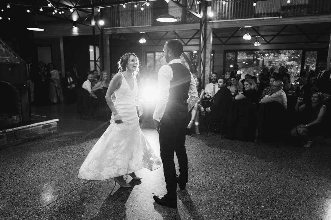 Black and white photograph of the couple dancing with bright light shining between them.