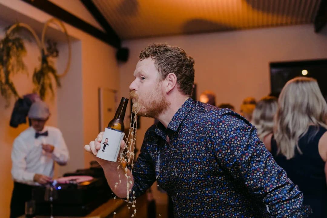 Guest drinks from a beer bottle during the reception.