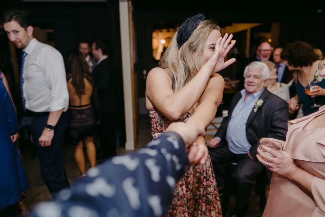 Guests dance together in a crowded reception room.