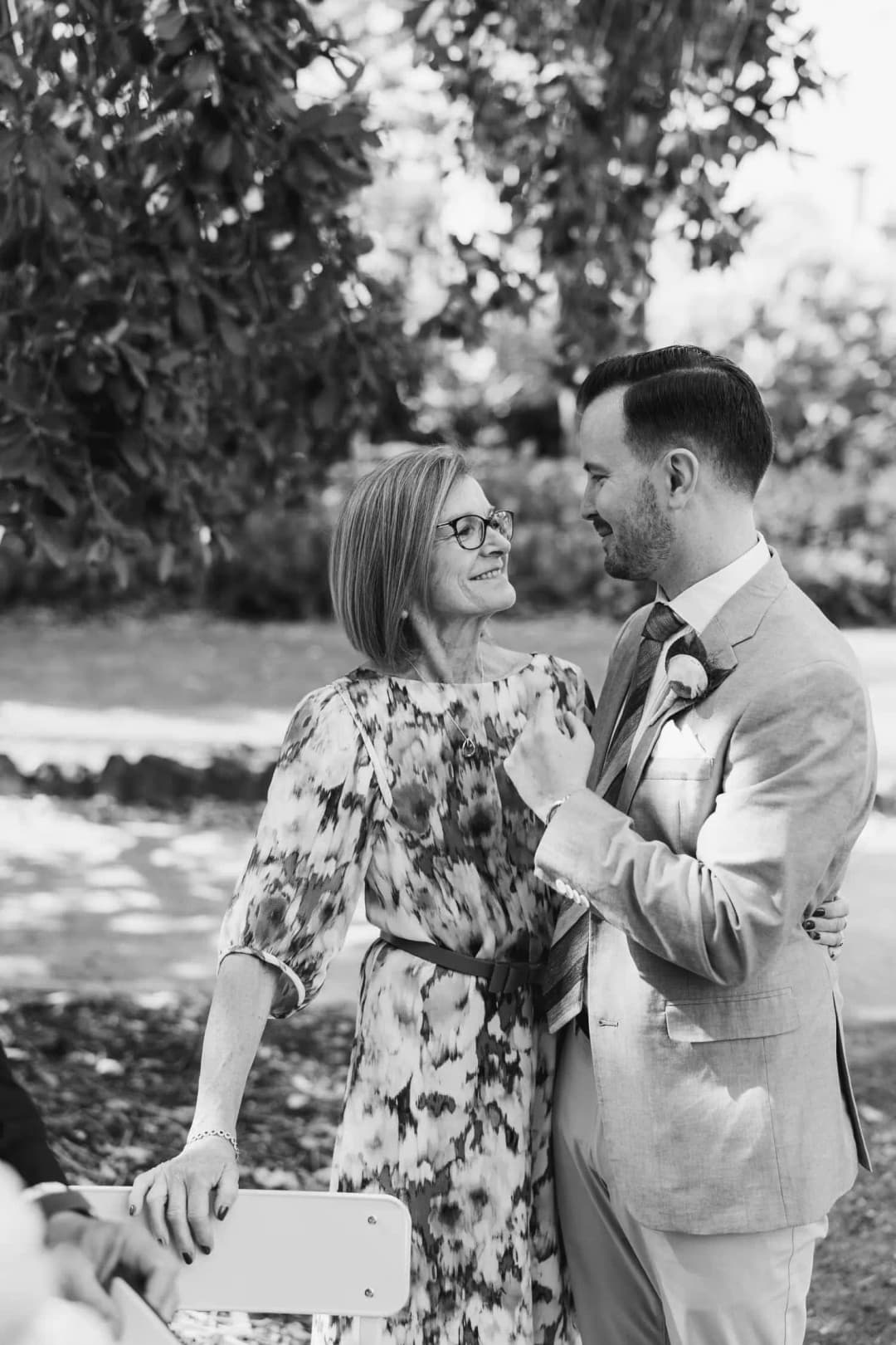 Black and white photograph of the groom dancing with an older woman outdoors.
