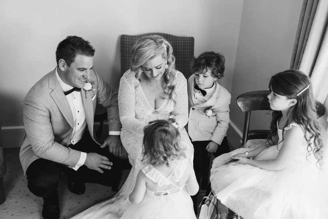 Black-and-white photograph of the bride and groom sitting with three children.