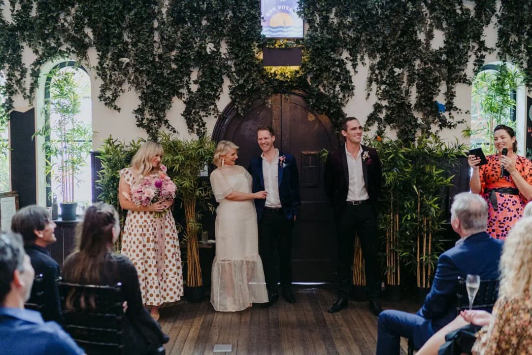 Wedding party standing before seated guests as the celebrant speaks