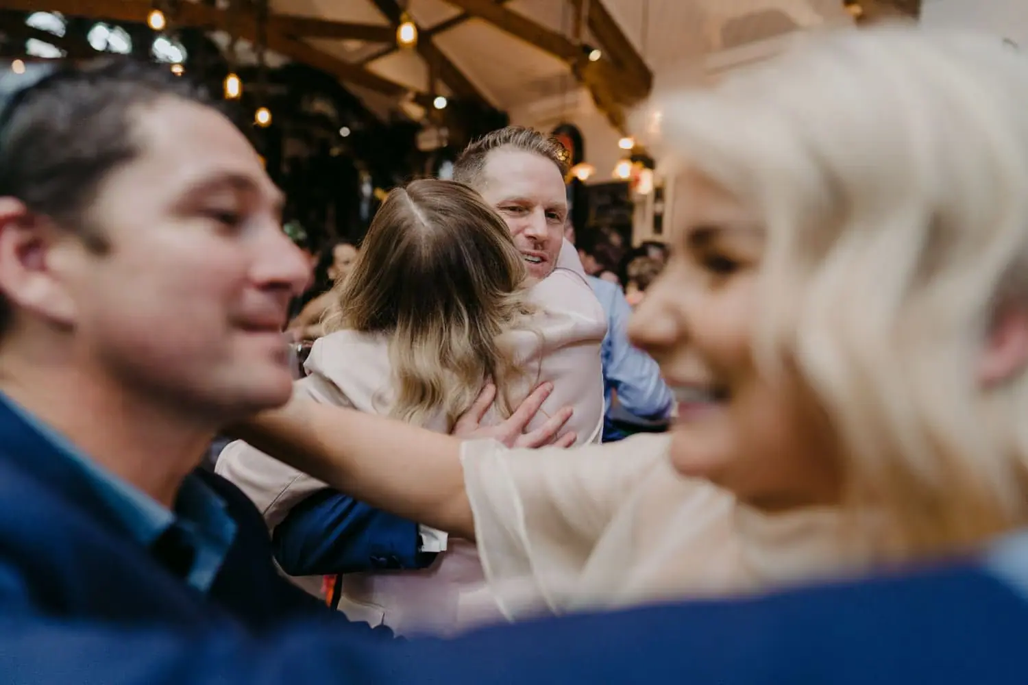 Bride greeting a guest with an arm around his shoulder