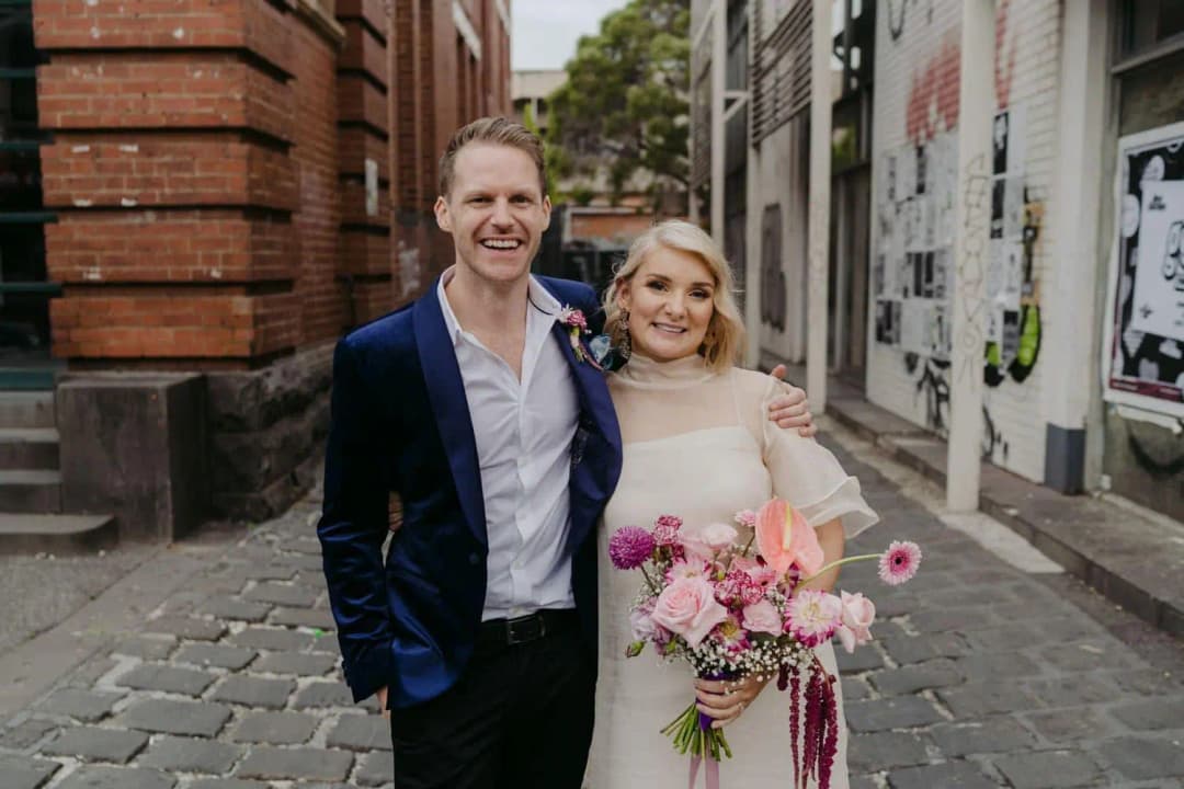 Bride and groom smiling together in a cobbled laneway