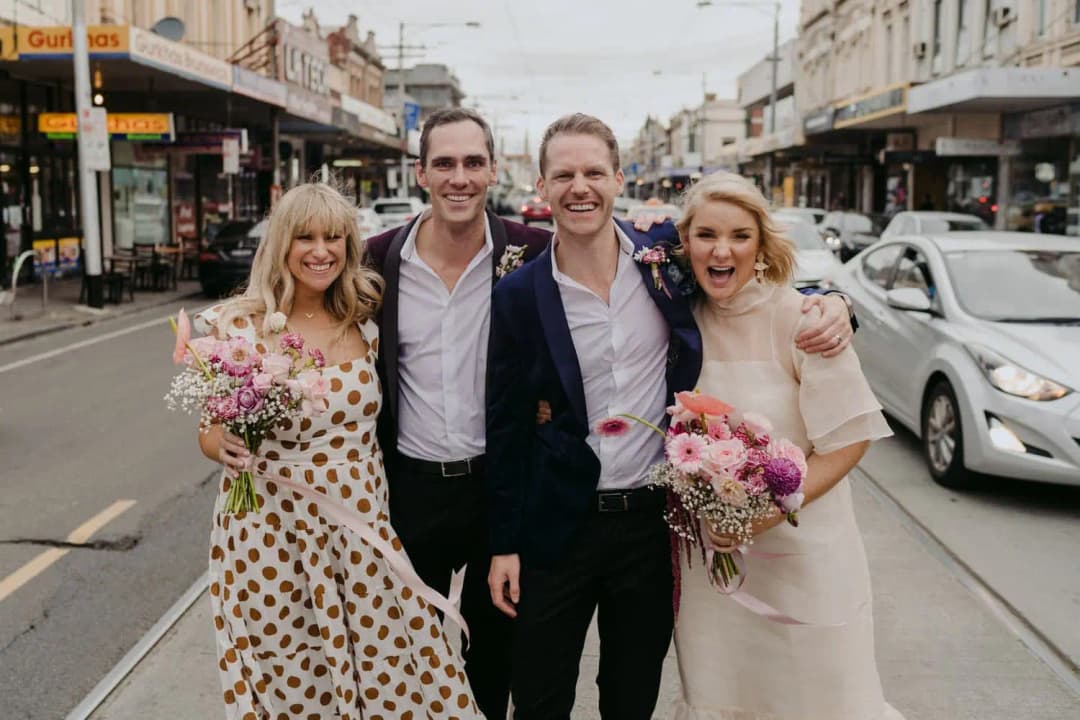 Four wedding party members posing together on a shopping street