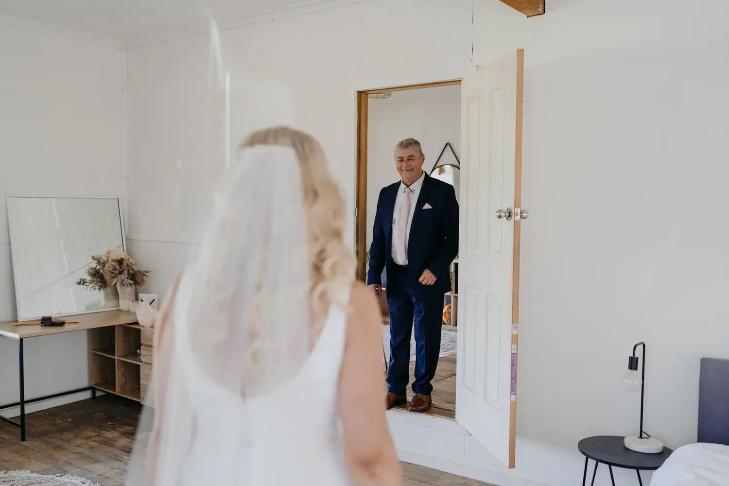 Bride approaching an older man waiting in a doorway