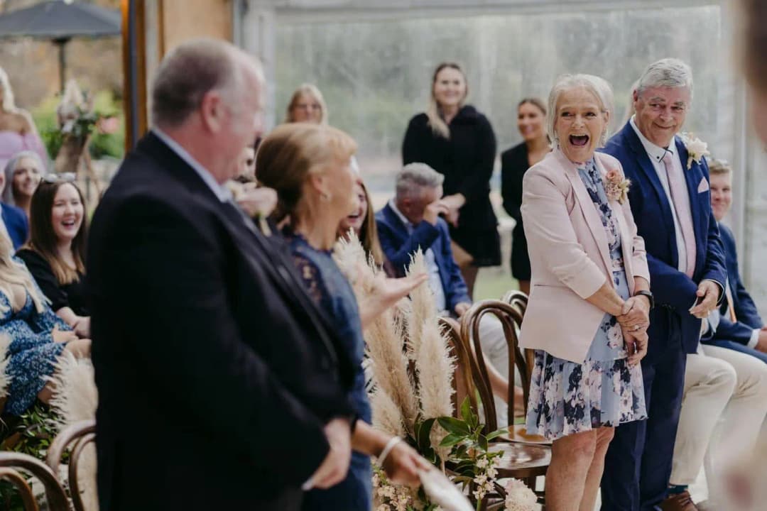 Guests laughing and reacting together during the ceremony