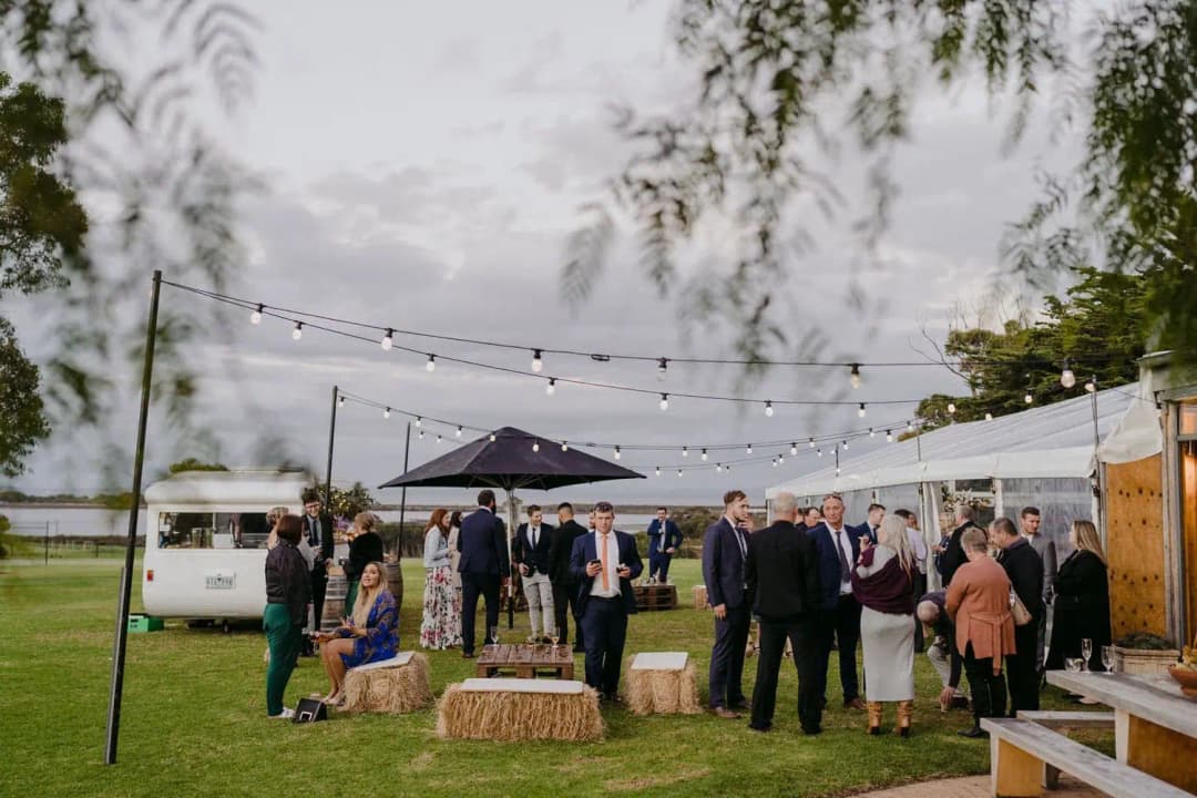 Guests gathered on the lawn beneath strings of lights