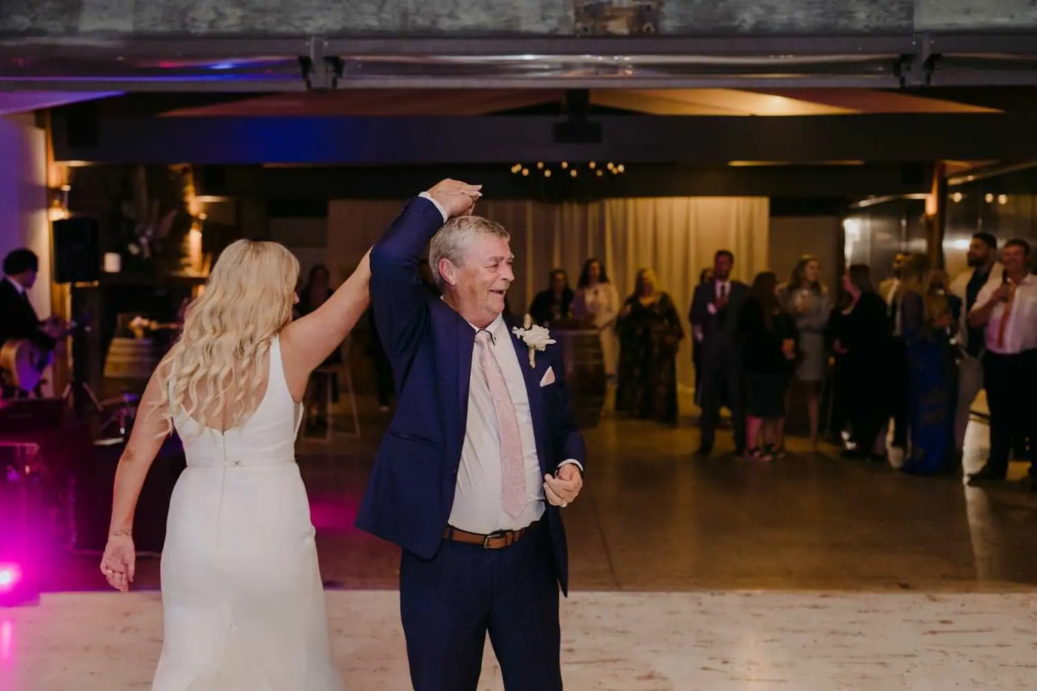 Bride twirling an older man across the dance floor