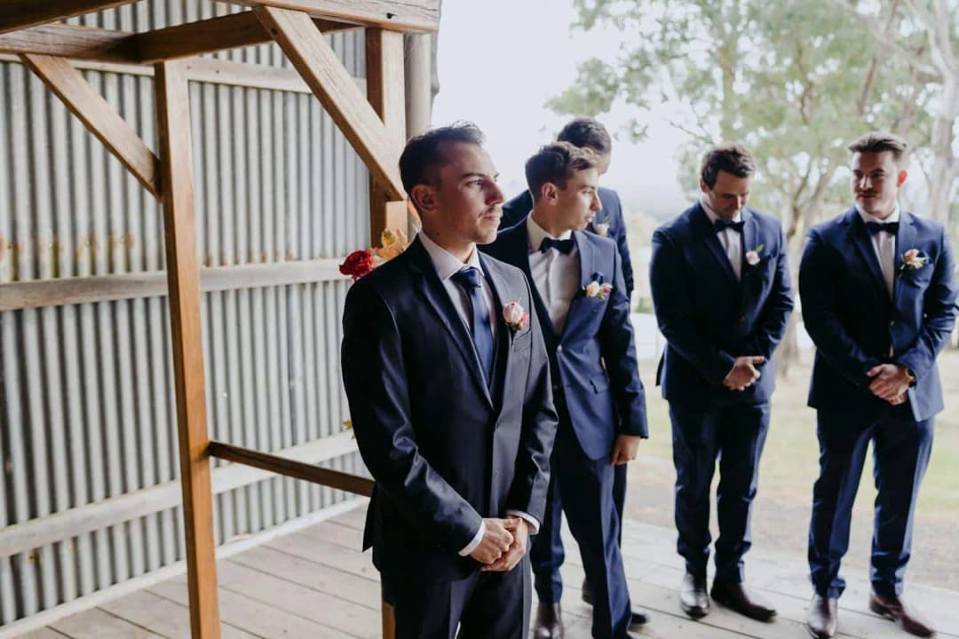 Groom and groomsmen waiting inside the ceremony shed
