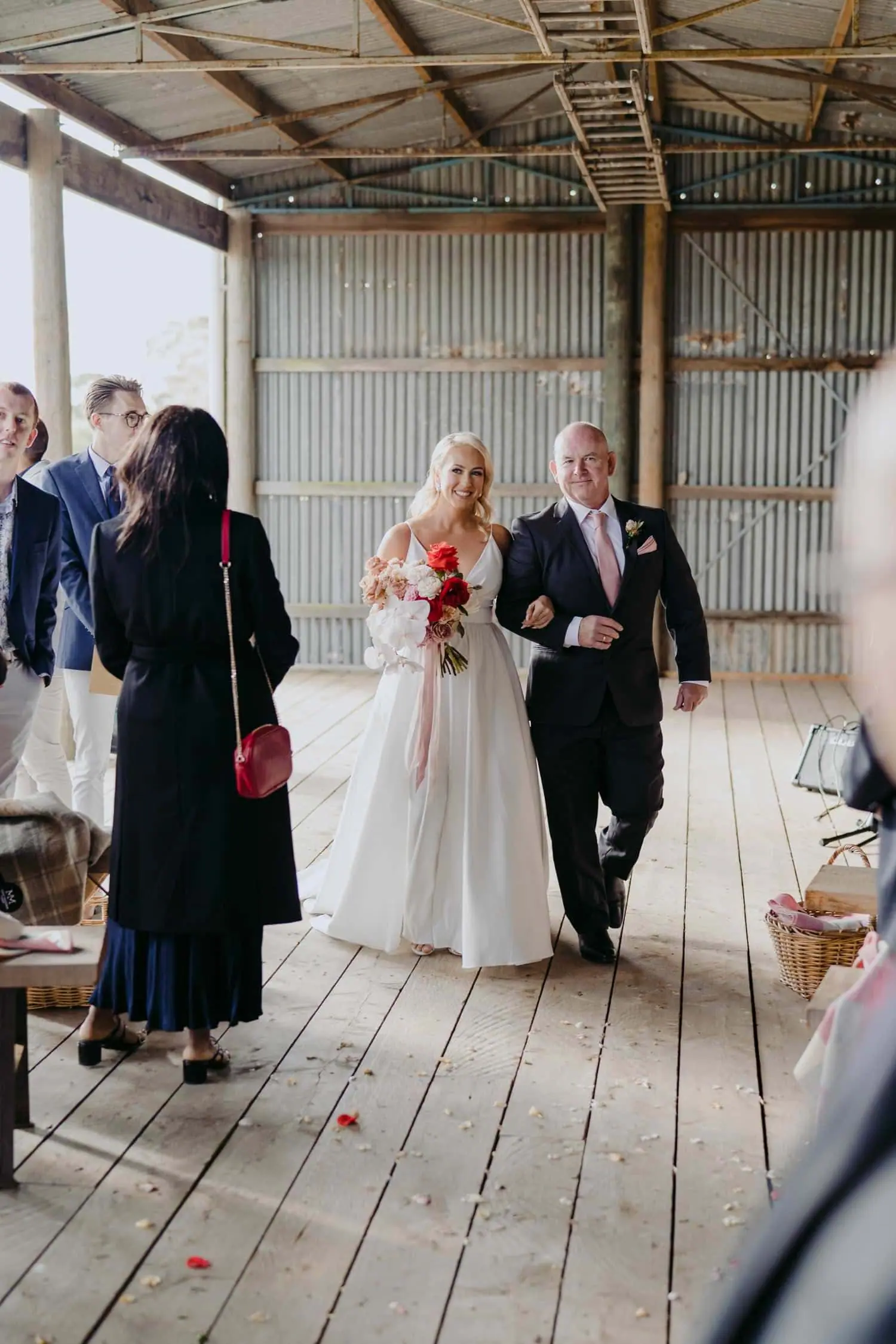 Bride entering the ceremony beside a suited man