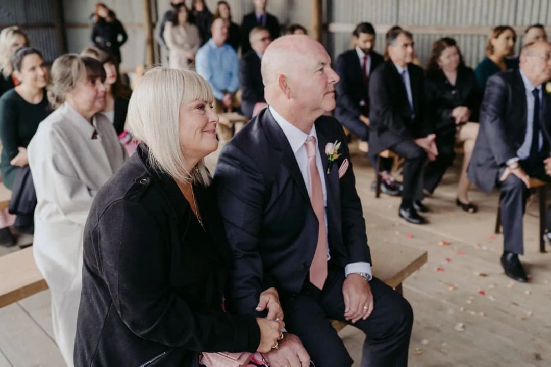 Two guests smiling together in the front row of the ceremony