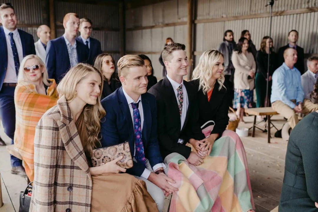 Seated guests watching the ceremony with a checked wrap and blankets