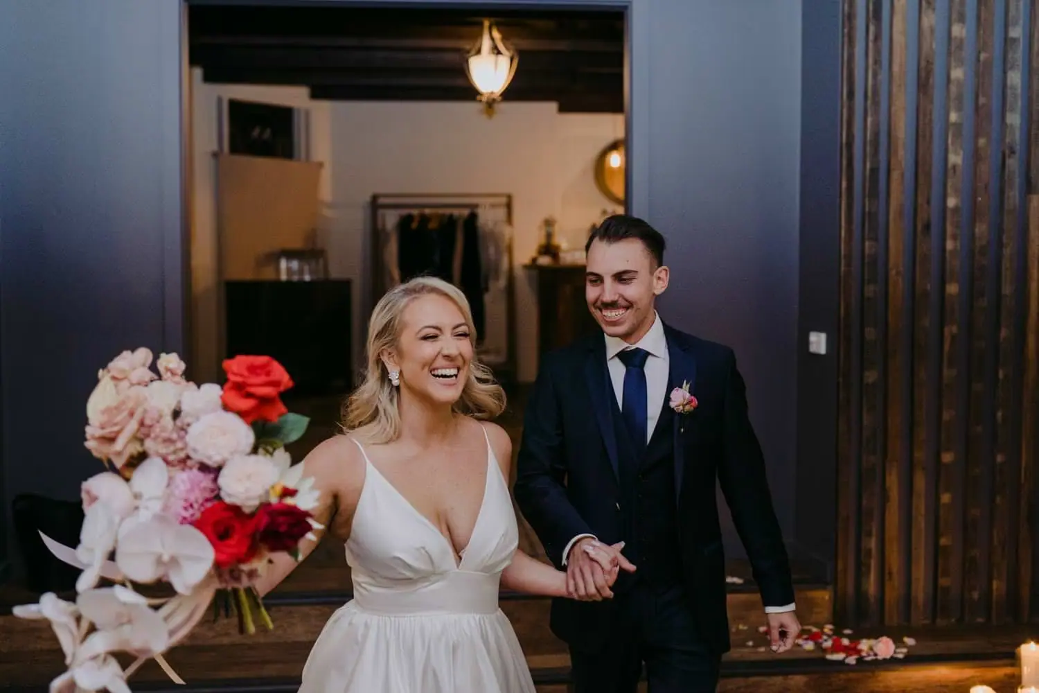 Bride and groom entering the reception with her bouquet held outward