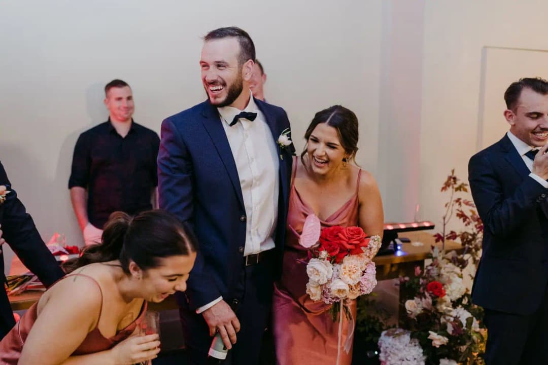 Groomsman and bridesmaids laughing together inside the reception