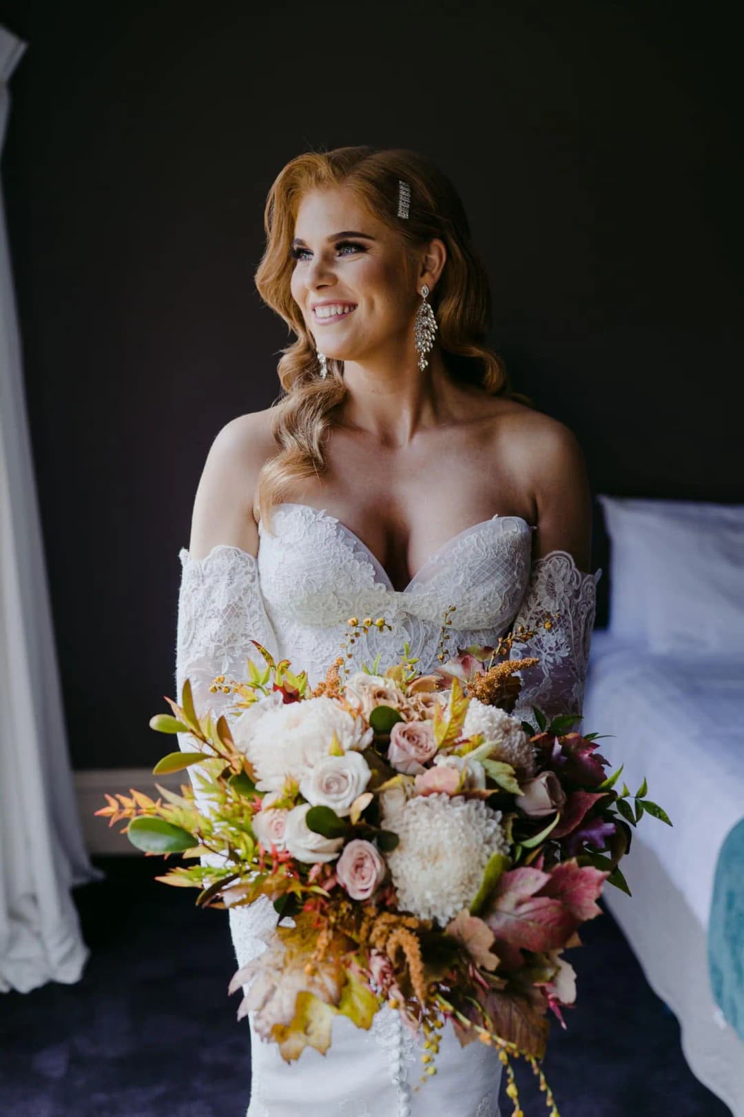 Bride smiling while seated with her colourful bouquet