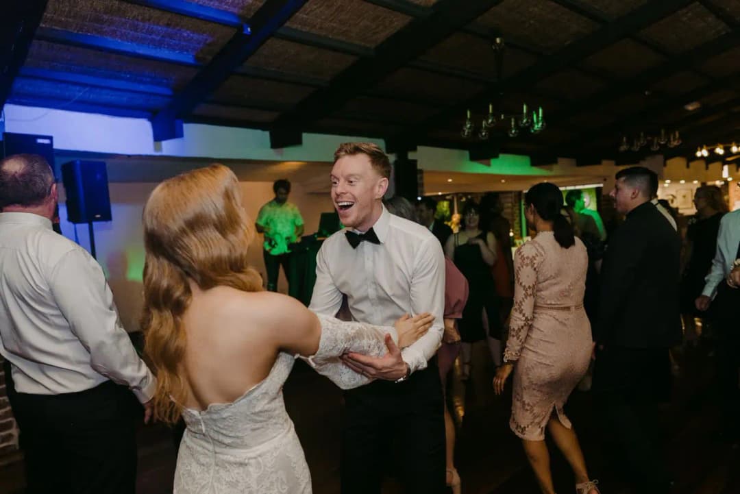 Bride and groom laughing together on the dance floor