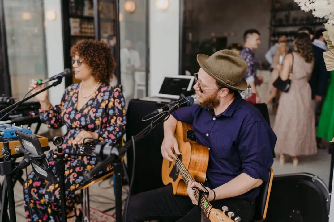 Singer and guitarist performing beside the outdoor reception area