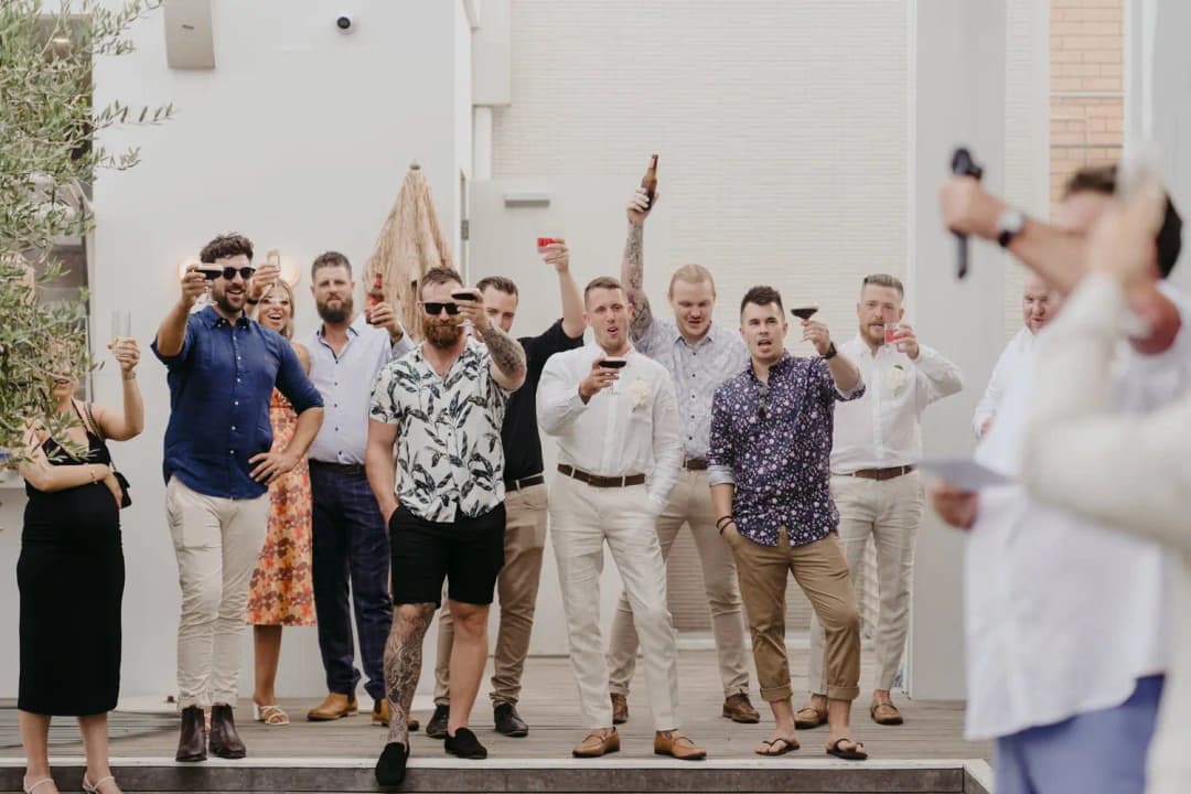 Guests cheering and raising their arms in the outdoor reception garden