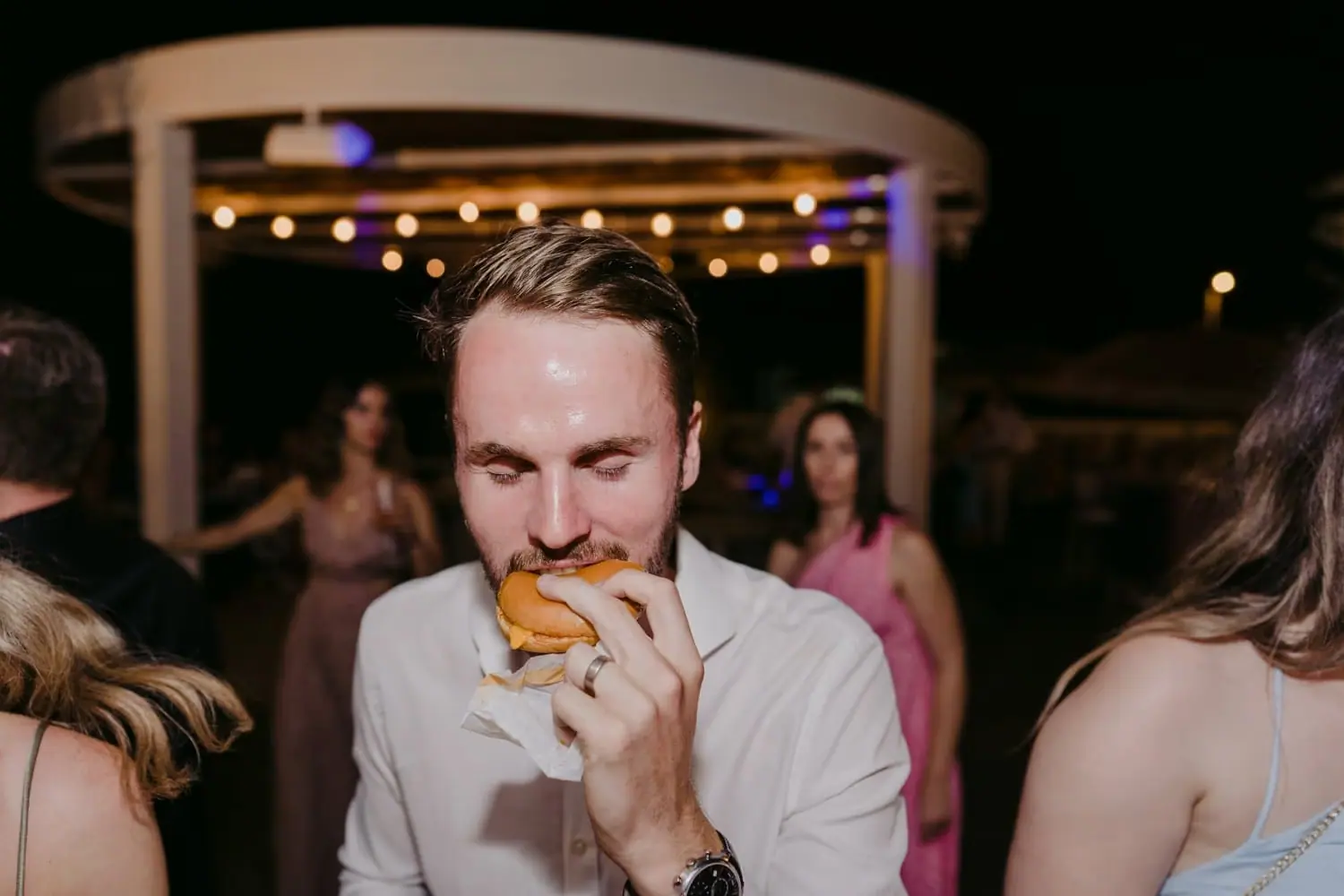 Guest eating a burger outside the reception at night