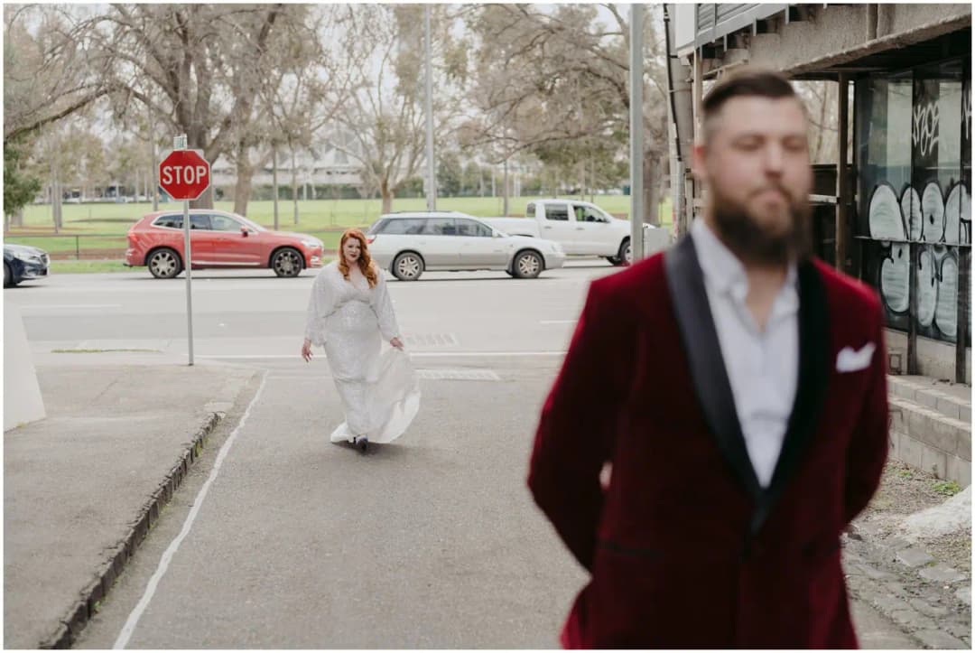 Bride walking toward the waiting groom along a city laneway