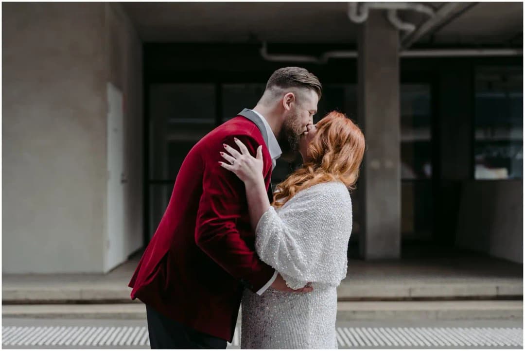 Bride and groom kissing outside an industrial building