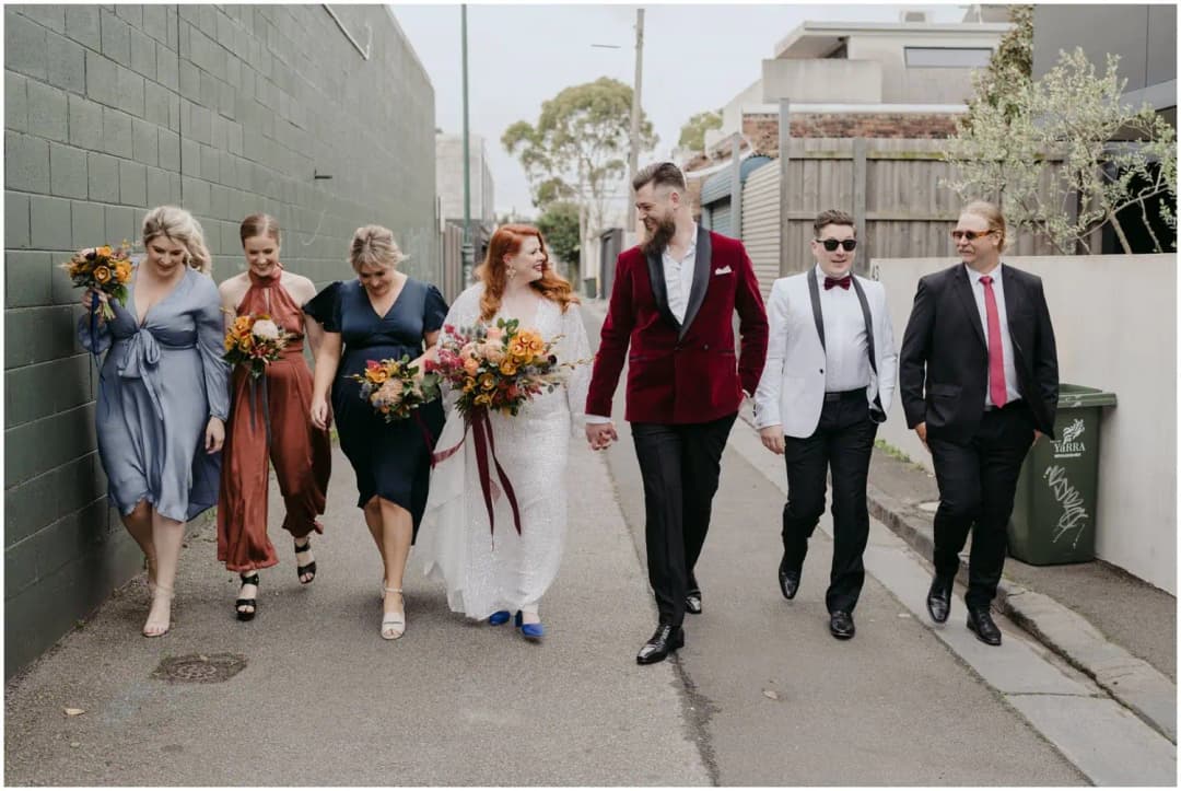 Wedding party walking together along a narrow city laneway