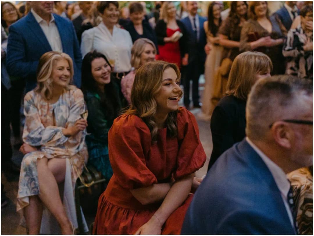 Seated guests laughing during the wedding ceremony