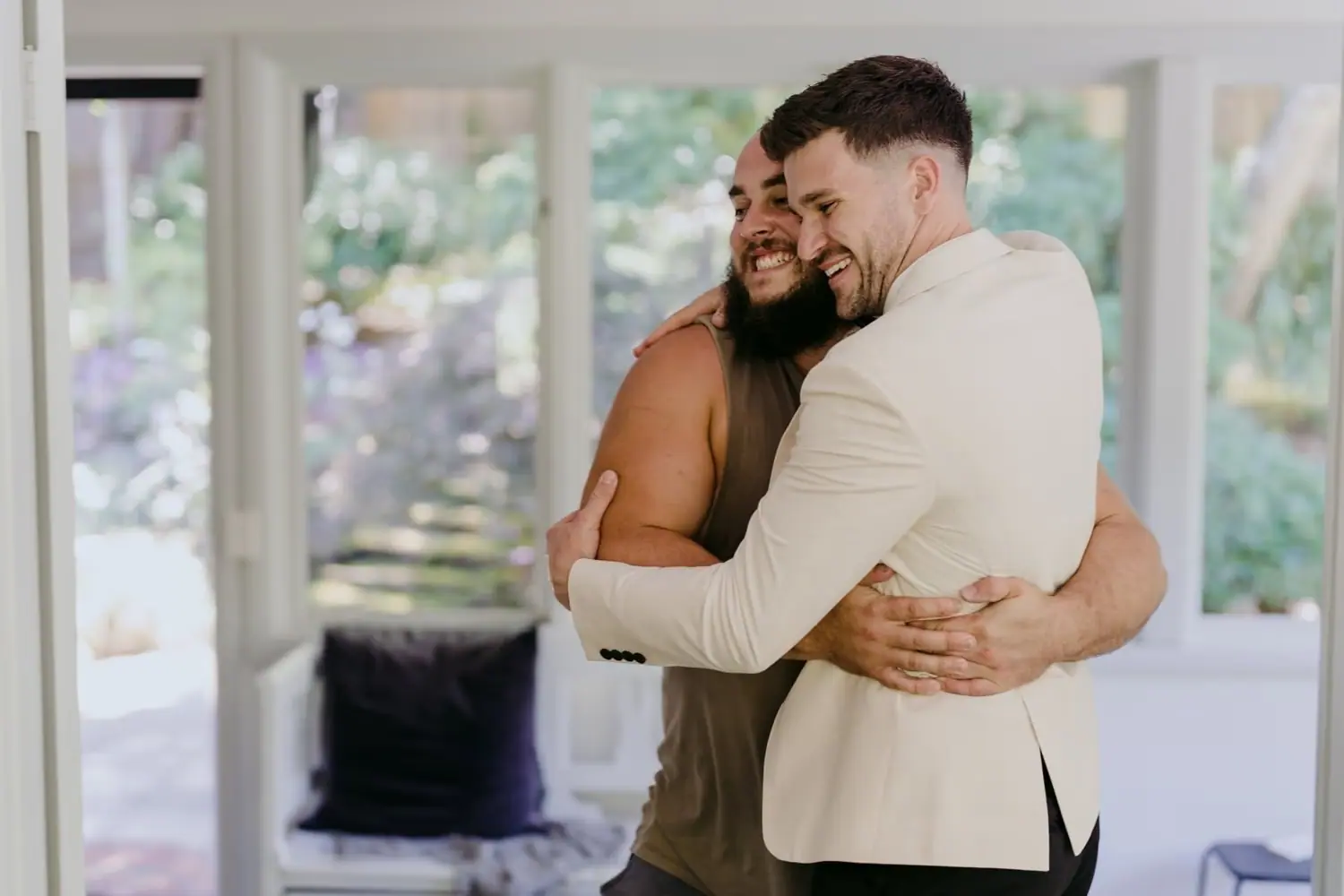 Groom hugging a woman inside a bright cabin