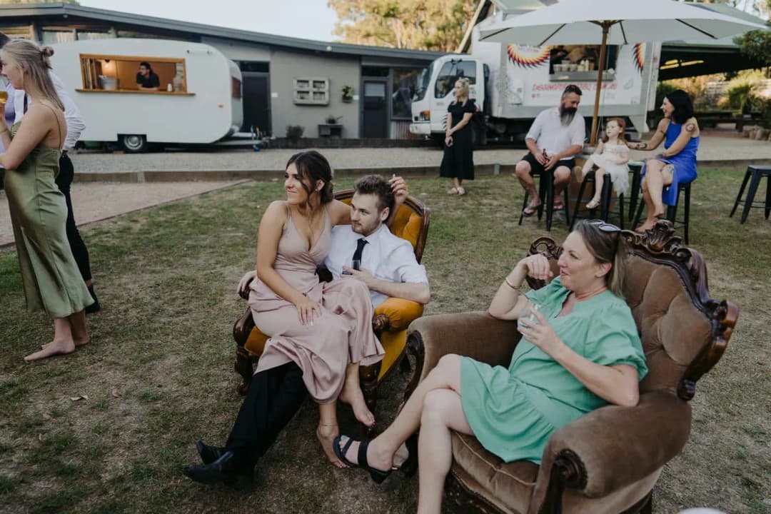 Guests relaxing on antique chairs and sofas on the lawn