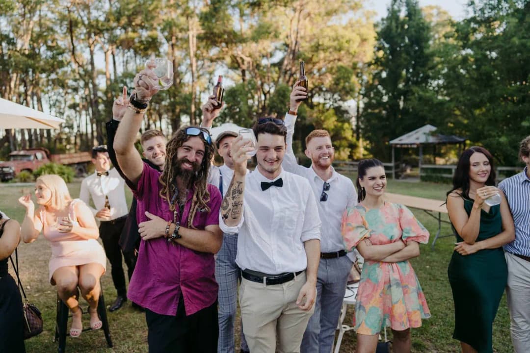 Guests smiling and raising their drinks outside the barn
