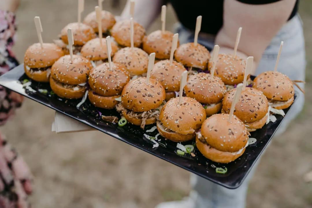 Tray of small burgers secured with wooden skewers