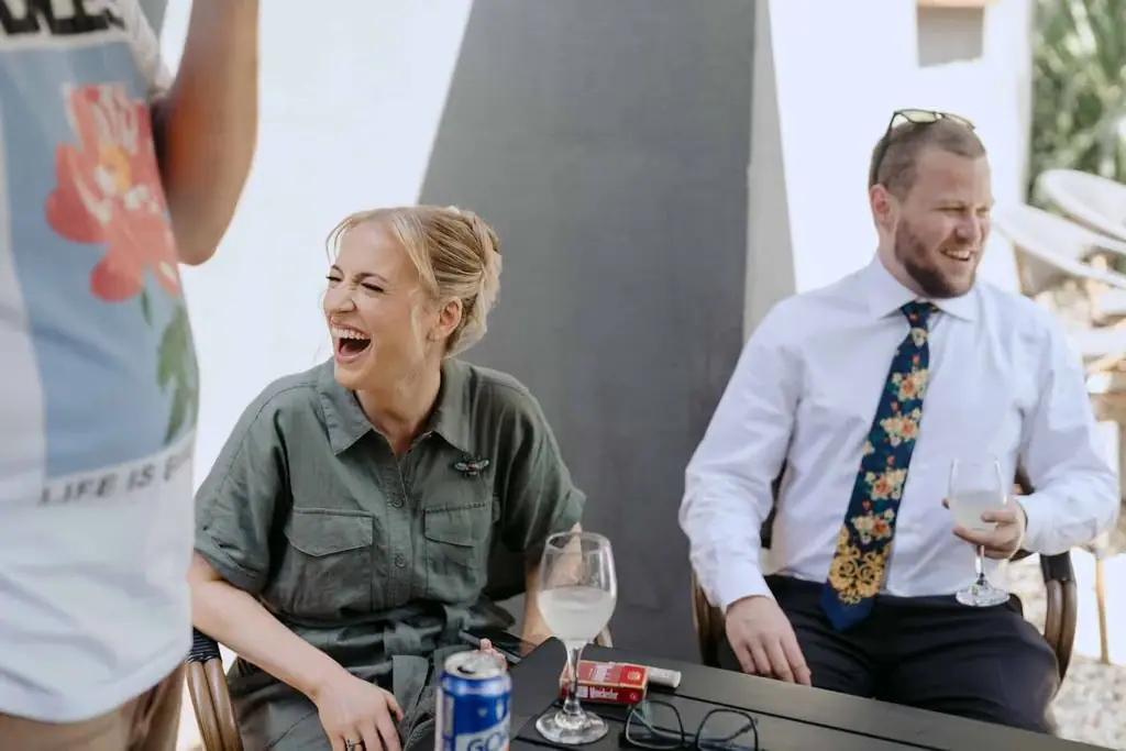 Guests laughing around a table before the wedding