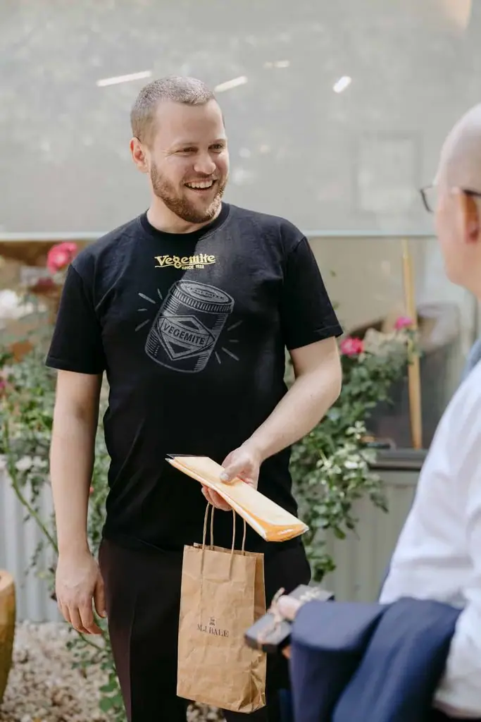 Guest holding a wooden hanger while talking