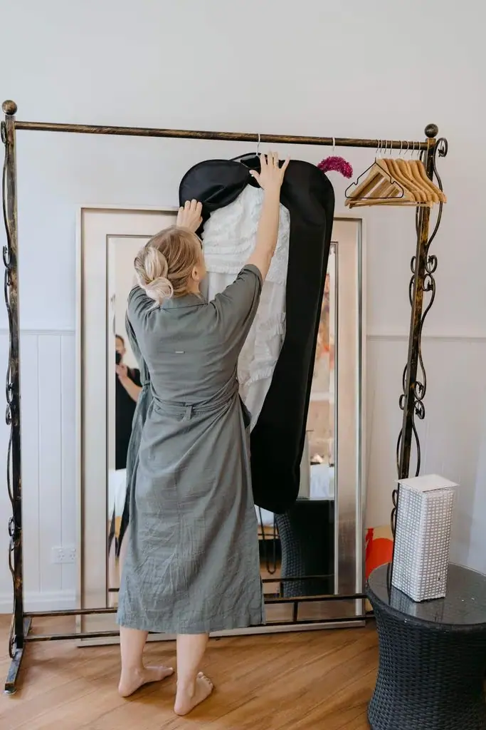 Guest reaching for clothing on a hanging rail