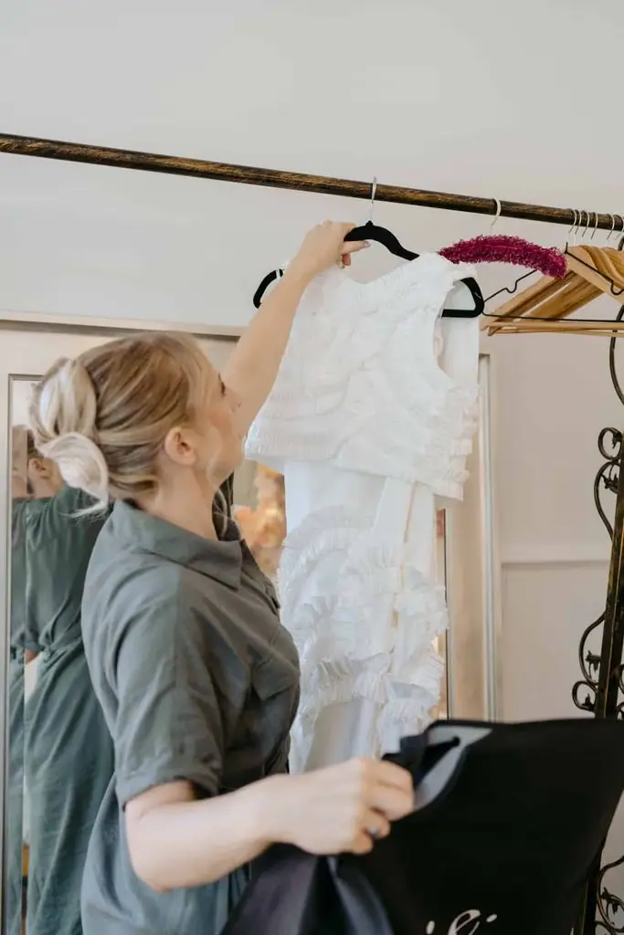 Guest taking the wedding dress from a clothing rail