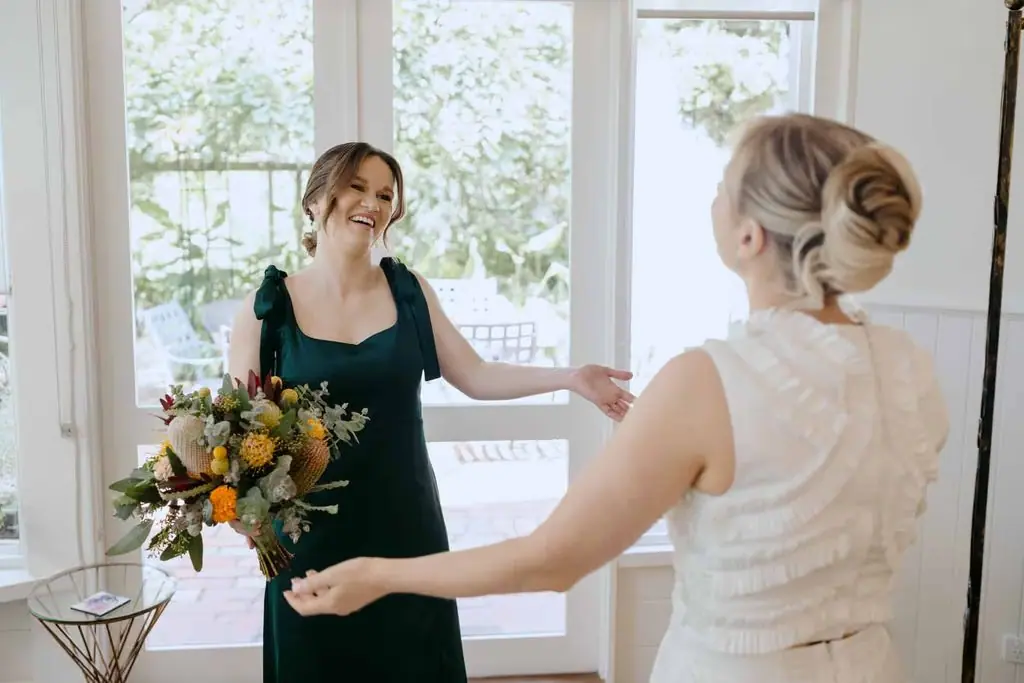 Bride greeting a friend while holding her bouquet