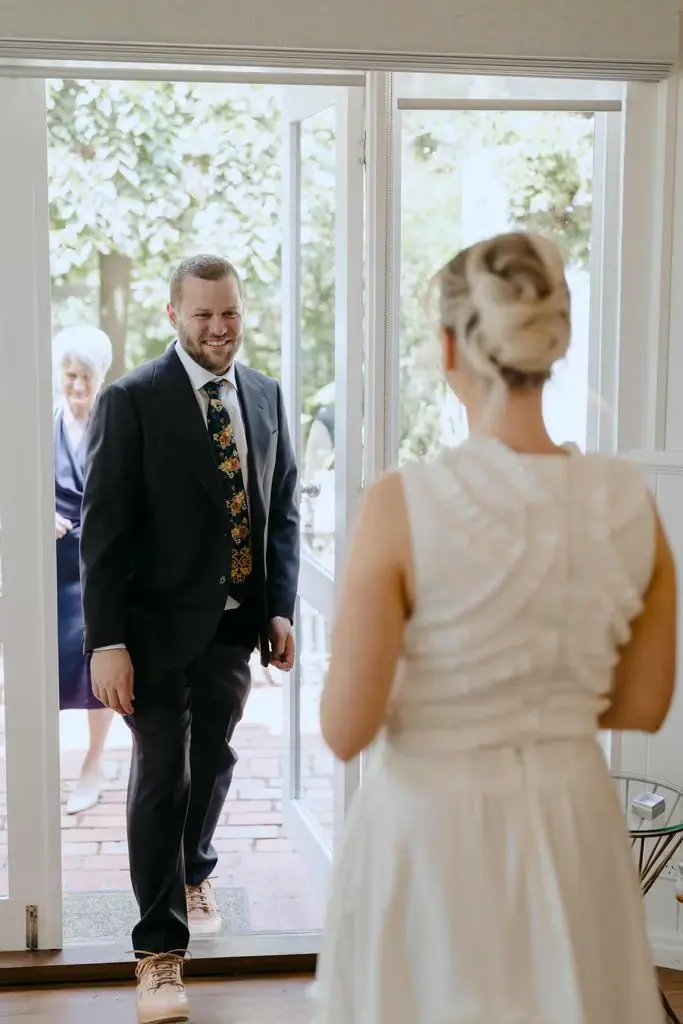 Groom approaching the bride indoors