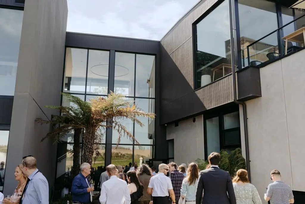 Guests gathered beneath a floral arbour outside the venue