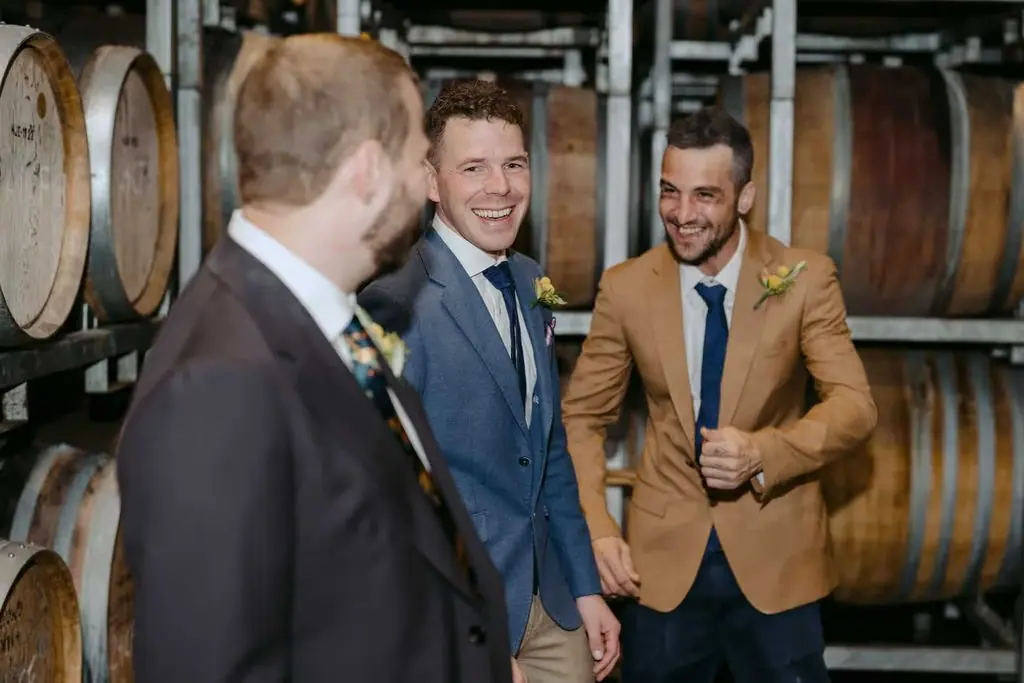 Groomsmen laughing together in the barrel room
