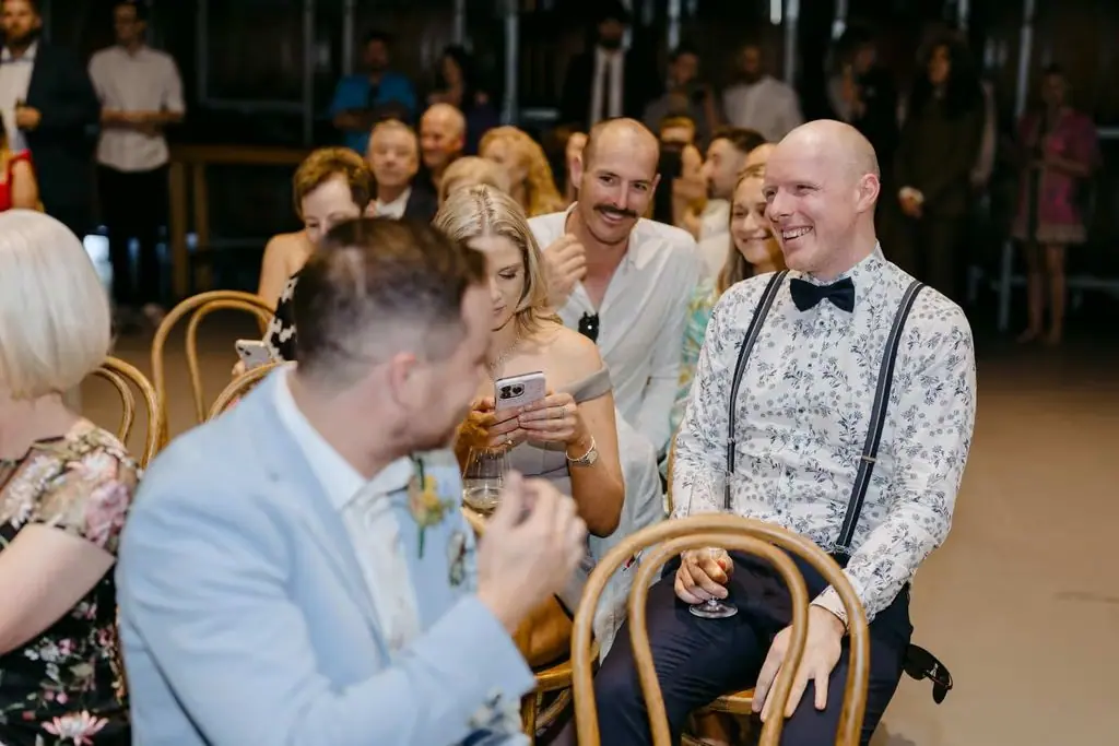 Guests smiling and chatting while seated for the ceremony