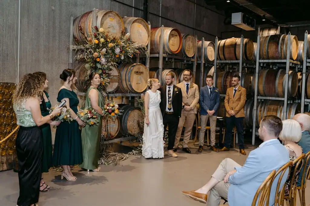 Wide view of the wedding ceremony among wine barrels
