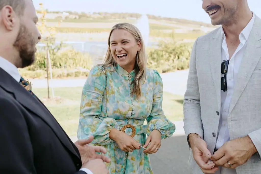 Couple talking with a smiling guest in the sunlight